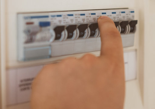 Male Hand Switching On Fuse Board.