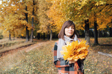 Autumn girl walking in city park. Portrait of happy lovely and beautiful young woman in forest in fall colors.