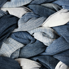 fashion stylish textured fabric background of many plaits and braids woven of blue jeans of...