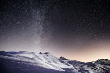 Illuminated ski slopes with night sky