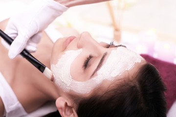 Obraz na płótnie Canvas Spa therapy for young woman having facial mask at beauty salon