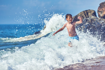 Fototapeta premium Cute Caucasian boy in sea waves.