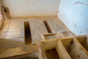 Indoor view of a stoned room with some holes inside of a building in Amber, India