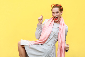 Win! Ginger woman rejoicing for his success. Isolated on yellow background.