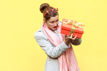 Hmm what is it! Cunning woman looking at gift box and want too open.