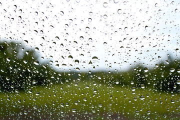 Droplets on a window facing a garden landscape
