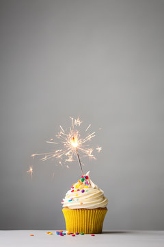 Cupcake with sparkler on grey