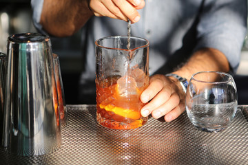 Barkeeper bereitet mischt einen Cocktail