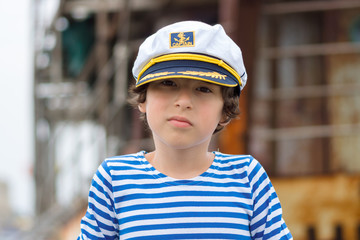 Portrait of a boy in a striped long sleeve T-Shirt (Telnyashka) and captain's cap.