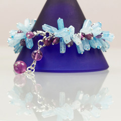 Silver jewels with colorful precious stones and light grey background
