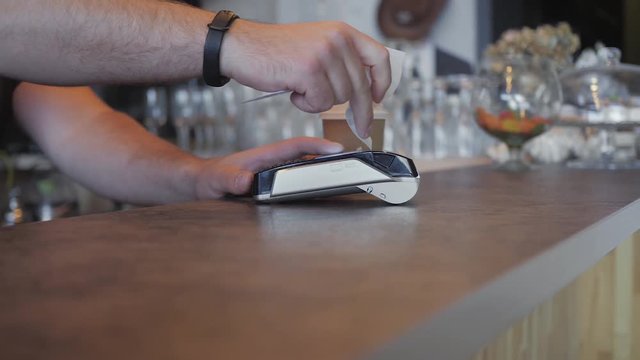 Making payment with credit card and pos terminal, printed check. a coffee shop