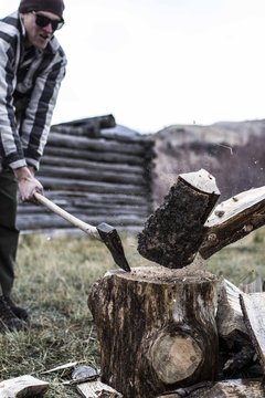 Man chops wood at his campsite in Montana.