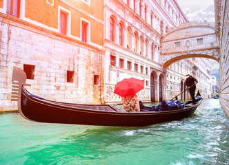 Fototapeta na wymiar Female traveler in Gondola passing over Bridge of Sighs in Venice