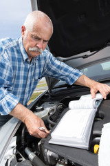 Fototapeta na wymiar older man checking levels and servicing his car