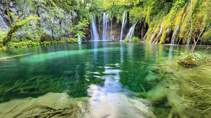 Close up of blue waterfalls in a green forest during daytime in Summer.Plitvice lakes, Croatia