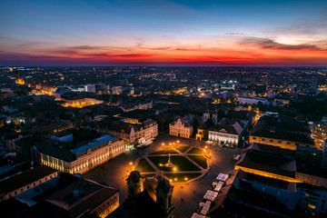 Fototapeta premium Union Square Timisoara - aerial view at blue hour with nice red horizon over the city lights