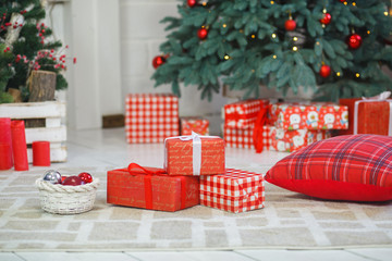 Christmas presents/gifts under fir-tree. Vintage New Year decorations. Red gift boxes and lantern nder fir-tree. Christmas mood. Celebrating of New Year