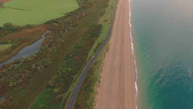 Car Driving on Scenic Ocean Highway, Aerial Drone Footage, Sandy Beach & Blue Waves