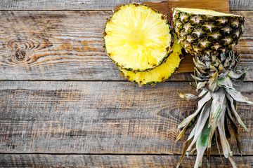 Obraz na płótnie Canvas Sliced pineapple on wooden background top view copyspace