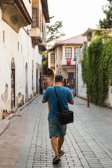 Fototapeta na wymiar Traveller with camera bag walking through the narrow streets of 