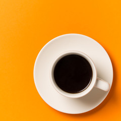 A cup of coffee isolated on orange . Top view.