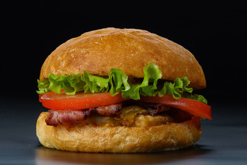 tasty burger with bacon and tomatoes