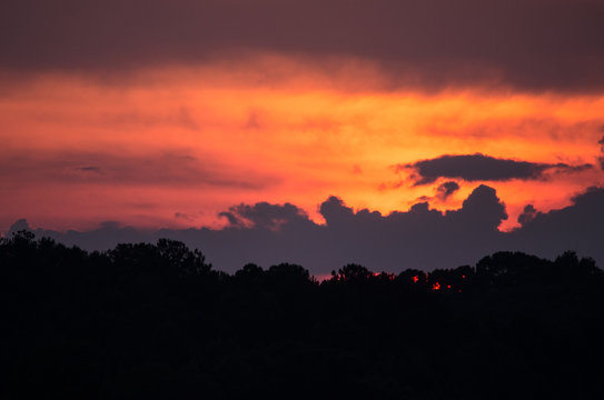 A summer sunset behind layers of clouds near Coldwater, Alabama, USA