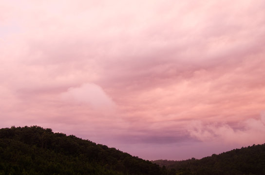Pre-sunrise clouds take on unusual colors as the sun nears the horizon in the hills near Anniston, Alabama, USA
