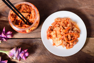 Korean food, kimchi cabbage on white dish and a jar with chopsticks for eating,top view of food