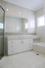 New white bathroom with granite bench top, tiled walls and floor