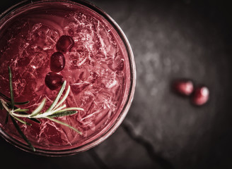 Pomegranate cocktail with rosemary sprig, top view