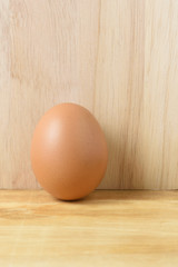 Fresh egg on a Brown wooden background.