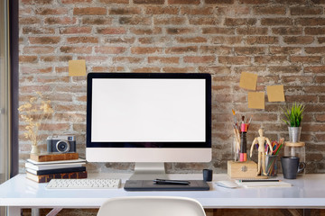 Fototapeta premium Mock up of blank screen desktop computer on the desk. Work space Mock up white tabletop vintage camera and pencils on white wood desk with copy space for products display montage.