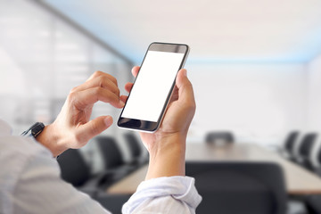 Mockup smartphone blank screen in man hands in blurred meeting room background.
