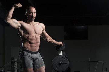Fototapeta na wymiar Bodybuilder Posing Double Biceps After Exercises