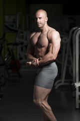 Fototapeta na wymiar Bodybuilder Posing Biceps After Exercises