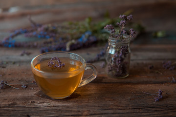 Green tea with herbals. Tea with oregano on the wooden background