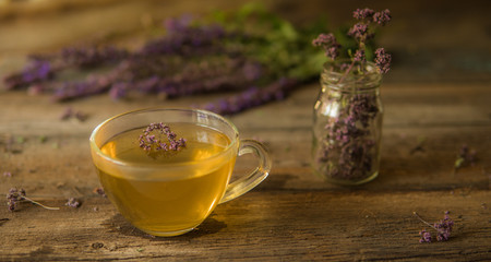 Green tea with herbals. Tea with oregano on the wooden background
