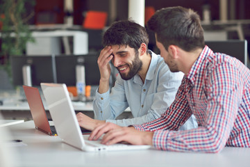 Multiracial contemporary business people working connected with technological devices like tablet and laptop