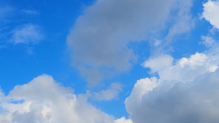 Wide screen grey big clouds in the middle and lower border, on light blue sky background