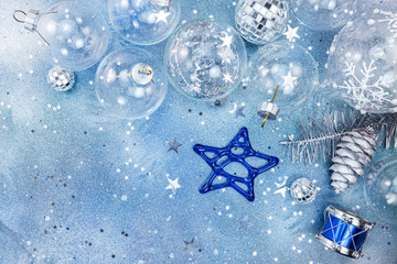 holiday decorations and small toy drum on blue background with star shaped confetti