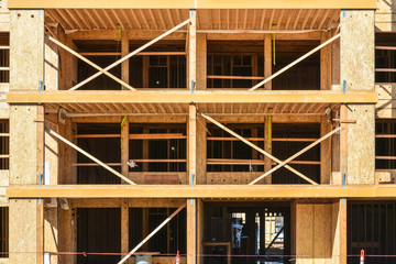 Fototapeta na wymiar Wooden framework of brand new low-rise building on sunny day