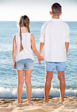 two chidren beach standing back
