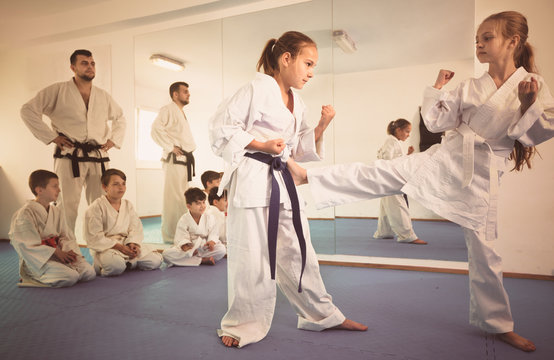 Pair of little girls practicing new karate moves during class