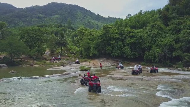 Motion above People Driving Quadricycles across Shallow River