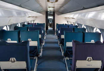 Empty seat rows in commercial old aircraft cabin.