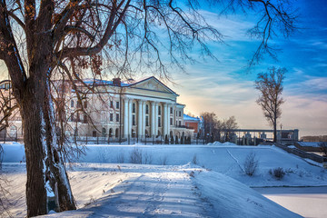 A beautiful building with columns on the banks of the Volga River next to the trees. Artistic noise...