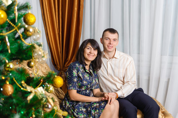 Happy family on Christmas tree background.