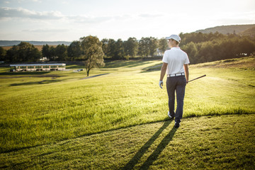 Man playing golf on a golf course in the sun