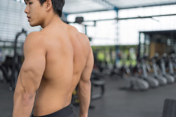 Fitness man showing muscular body in gym